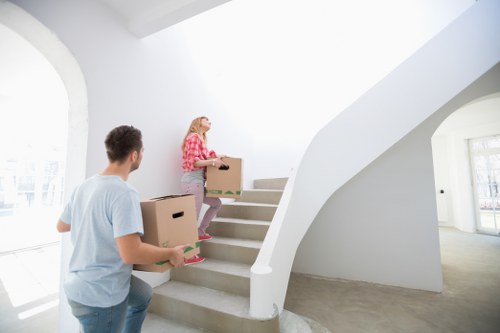 Piano removal team navigating stairs in a Kensington townhouse